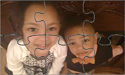 Screenshot of a puzzle with two kids. Little girl on left and boy on right.